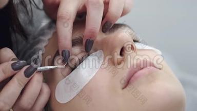 一个睫毛技师正在用一个工具把<strong>眼睫毛</strong>卷起来
